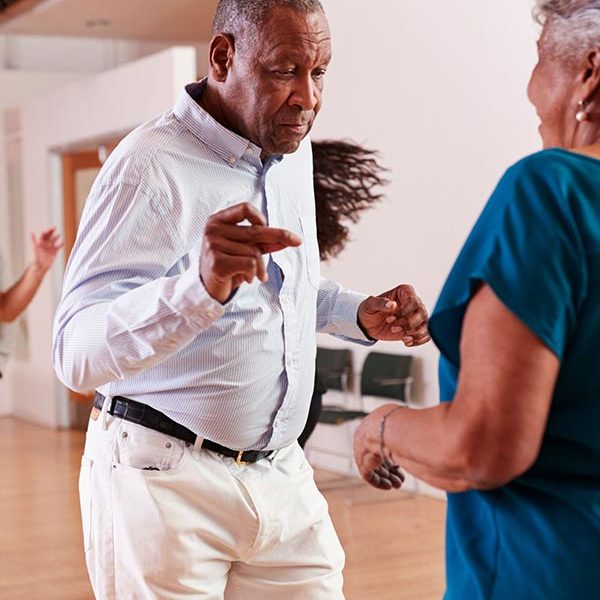 older man and woman dancing in home